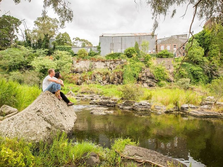 Therapeutic outdoor session by the Barwon River, with people sitting peacefully on a rock overlooking the water