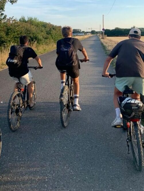 Group of young people cycling together on a nature trail during a movement-based therapy session